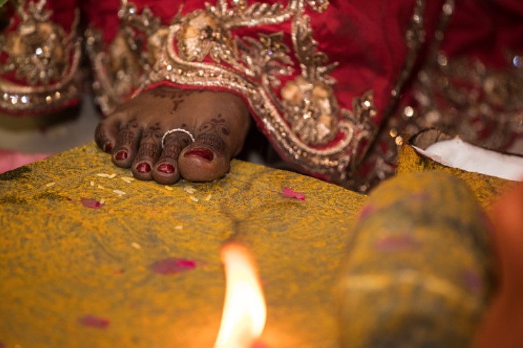 anillo de compromiso indio hecho de oro colocado en el dedo de un pie