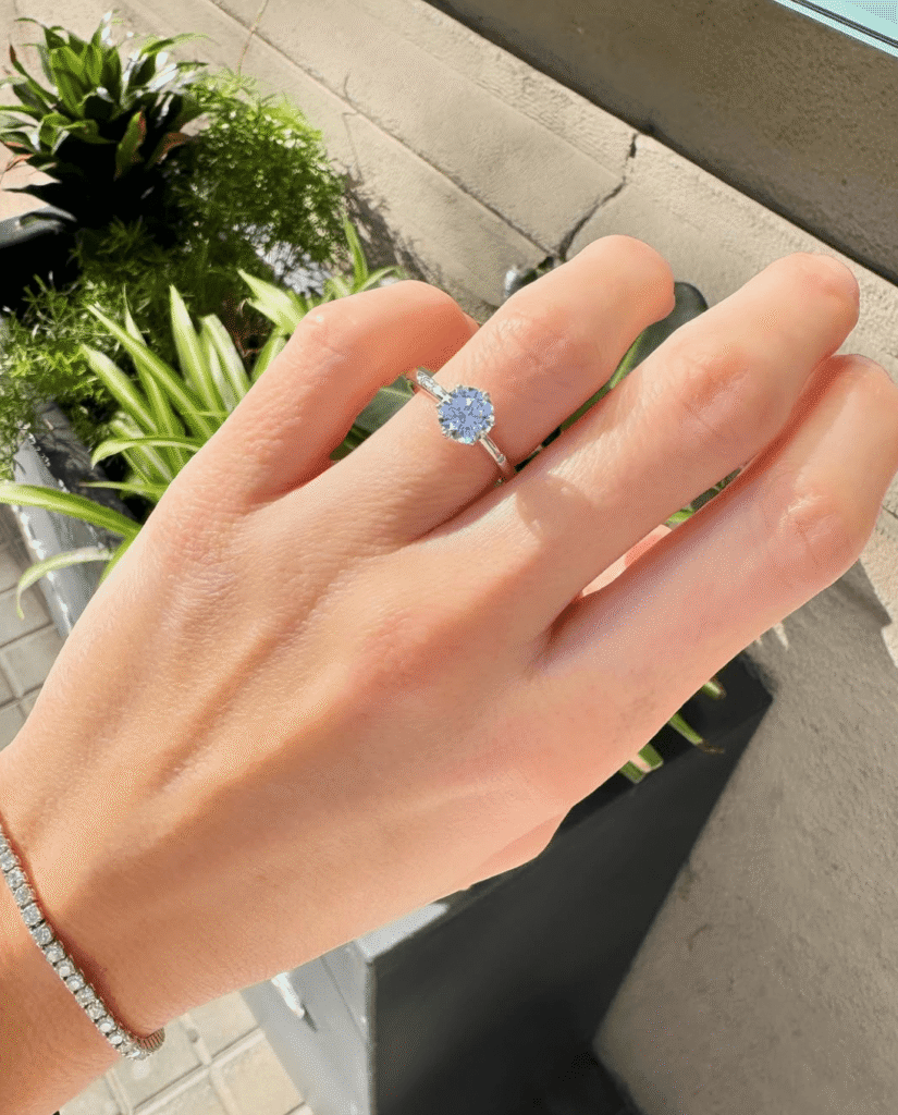 solitario de compromiso de oro blanco con diamante natural certificado colocado en el dedo anular de la mano izquierda