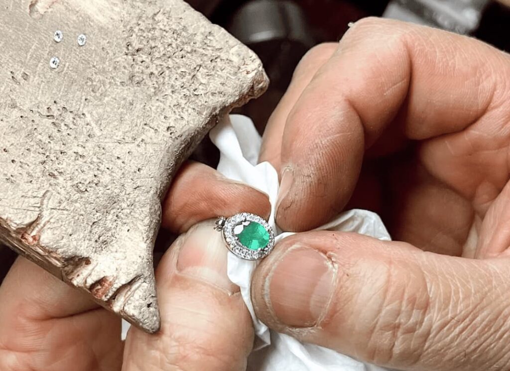 Experto joyero limpiando y cuidando una pieza de joyería de autor de forma artesanal