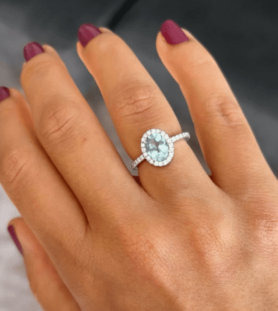anillo estilo solitario con aguamarina central rodeada con diamantes y realizada artesanalmente con oro blanco de 18kt